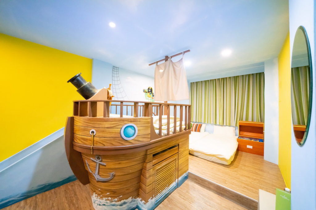 「築樂窩」也設有金銀島主題房，床鋪以海盜帆船造型設計。(圖片由Booking.com提供)