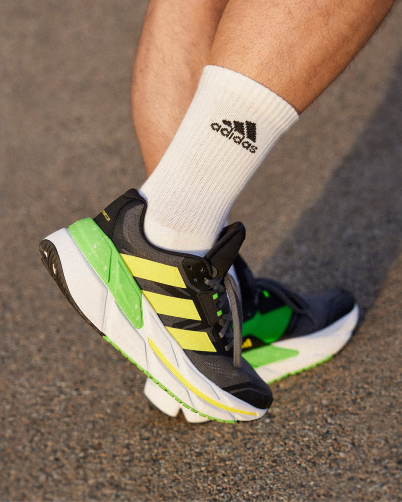 Adistar CS男款以黑色為基底，鞋側的三線標誌用搶眼的黃色抓住目光，輔以亮綠色點綴，讓你化身夏日跑道上的主角！