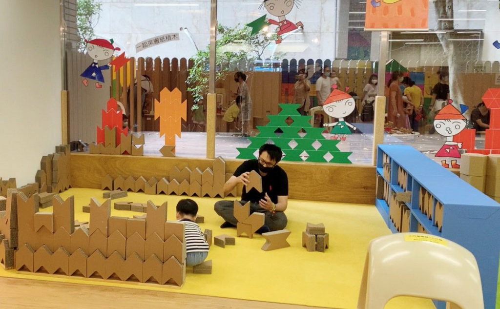 信誼親子館「積木玩具國」特別推出「H型紙積木」用瓦楞紙設計製作可直排、橫排堆砌體驗幾何圖形的大型紙製積木。親子都能樂在其中一起堆砌(信誼基金會提供)