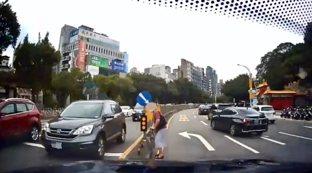 臺北市保大警利用警車警示來往用路人及保護老婦人安全。