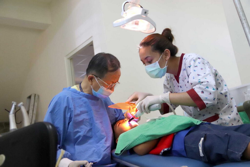 王剛毅醫師到偏鄉國小巡迴看牙超過二十一年，圖為2022年在土坂國小（達仁鄉）為孩子治療牙齒。
