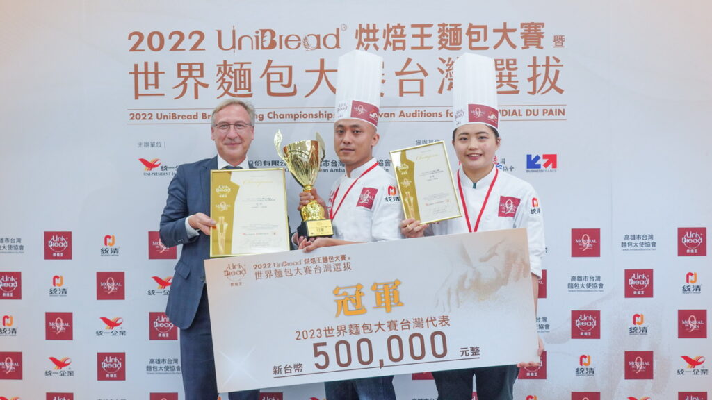 2022 UniBread烘焙王麵包大賽暨世界麵包大賽台灣選拔，冠軍得主茶天下王柏峰(中)及助手簡思昀(右)，左為頒獎人法國在台協會商務處處長François Cotier