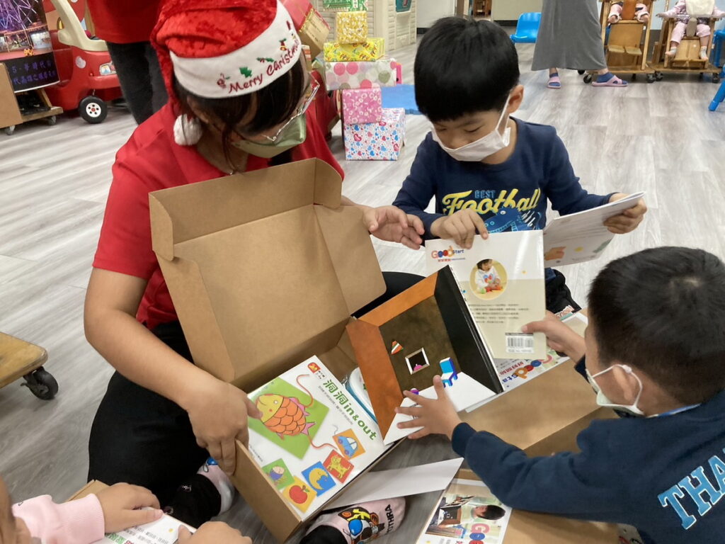 高雄市早療據點的老師們化身聖誕老公公送信誼禮物盒,孩子們拆封聖誕禮盒，既期待又興奮。 (高雄市社會局提供)