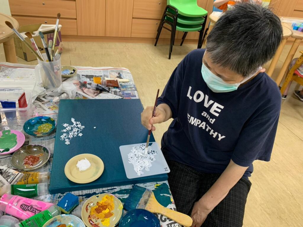 多重障礙的貞貞使用伊甸提供的填色繪畫模板作為輔具幫助創作，完成她人生第一幅完整的畫作─《盛開的杏花》