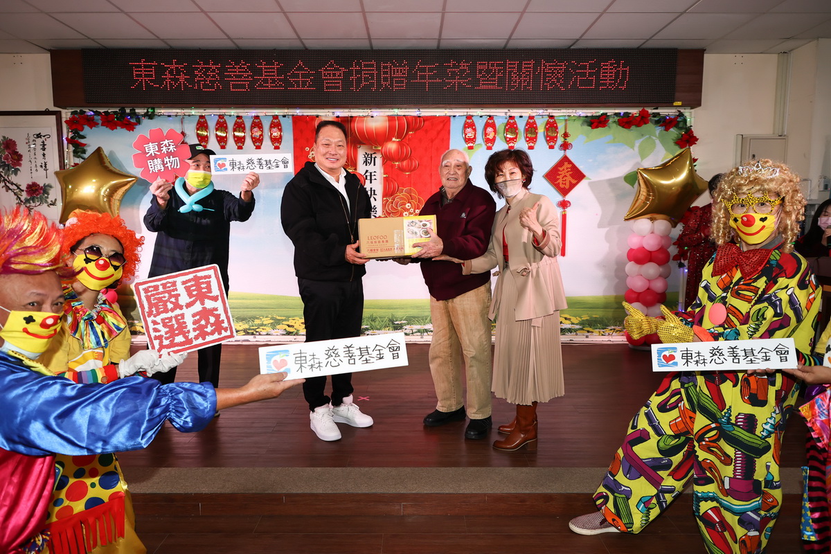 王令麟捐贈板橋榮民之家年菜組合，由榮民之家家主任陳桂美(圖左)陪同百歲人瑞(圖中)代