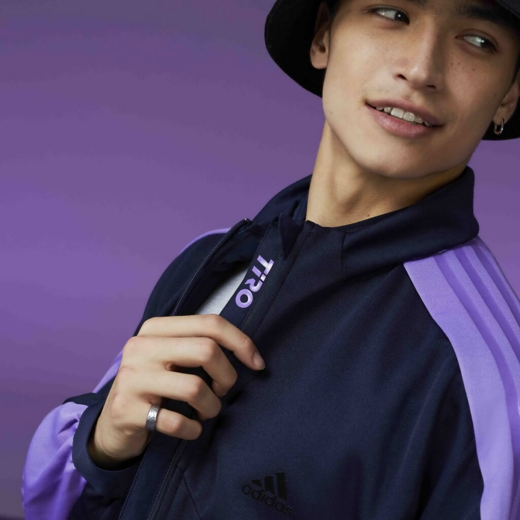 adidas Sportswear系列運動外套的內裡有印花字樣，增添細節驚喜，黑紫的簡約配色十分引人注目。