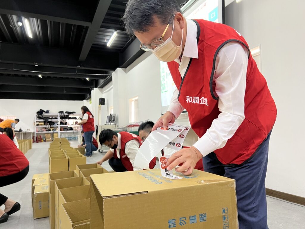 和潤企業總經理林彥良捲袖，與同仁一起包裝食物箱