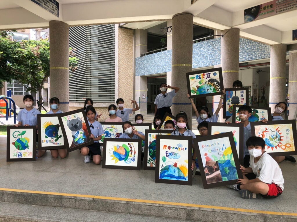 學生手拿親手創作綠能節能合影