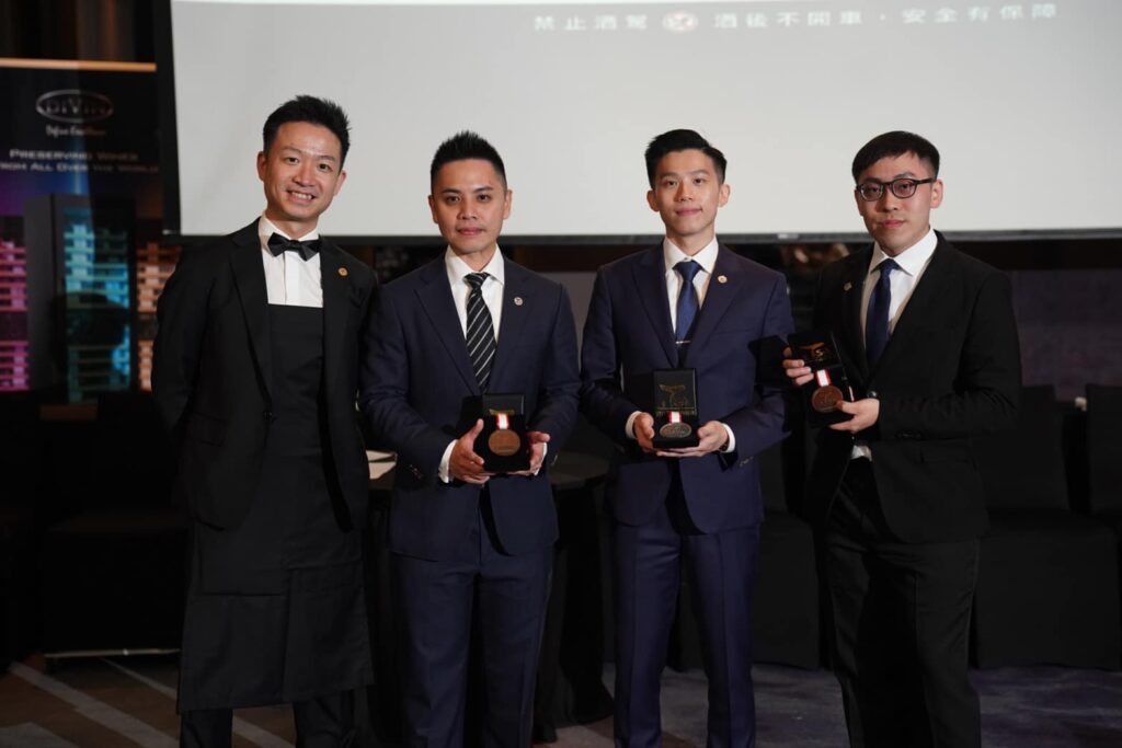 本次大賽由邱煥元獲得冠軍(左二)、亞軍張哲豪(右二)、季軍蘇芳緯(右一)，與世界最佳侍酒師大賽季軍Reeze Choi(左一)一同合影。社團法人台灣侍酒師協會/提供。