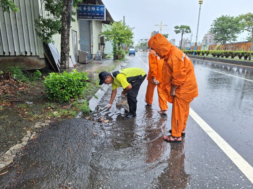 卡努颱風接近志工協助清除格柵樹葉及垃圾，使積水加速排入側溝