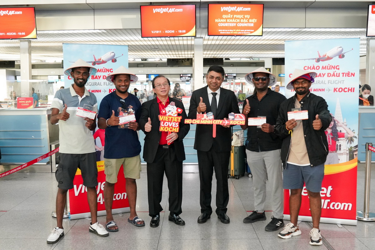 越捷副總經理杜春光（Do Xuan Quang）(左邊數來第三位)和印度駐胡志明市代表馬丹莫漢（Madan Mohan Sethi）(左邊數來第四個)在新山機場歡迎首位搭乘胡志明市-印度科欽首航的乘客