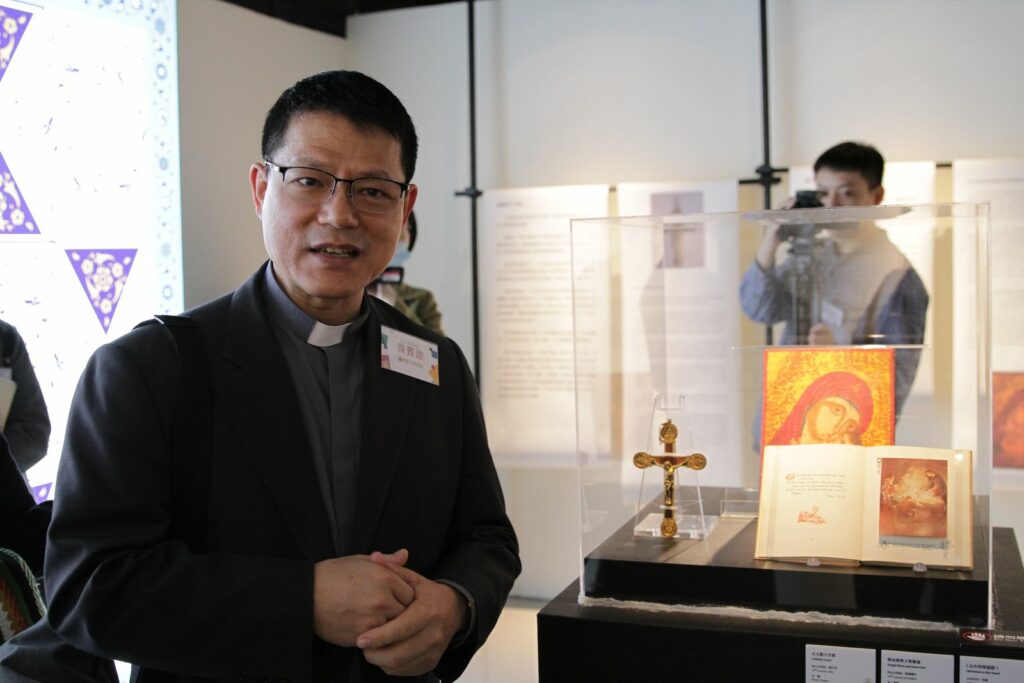 天主教台灣地區主教團宗教交談委員會執行秘書林之鼎神父，與3件基督宗教文物。（圖由世界宗教博物館提供）