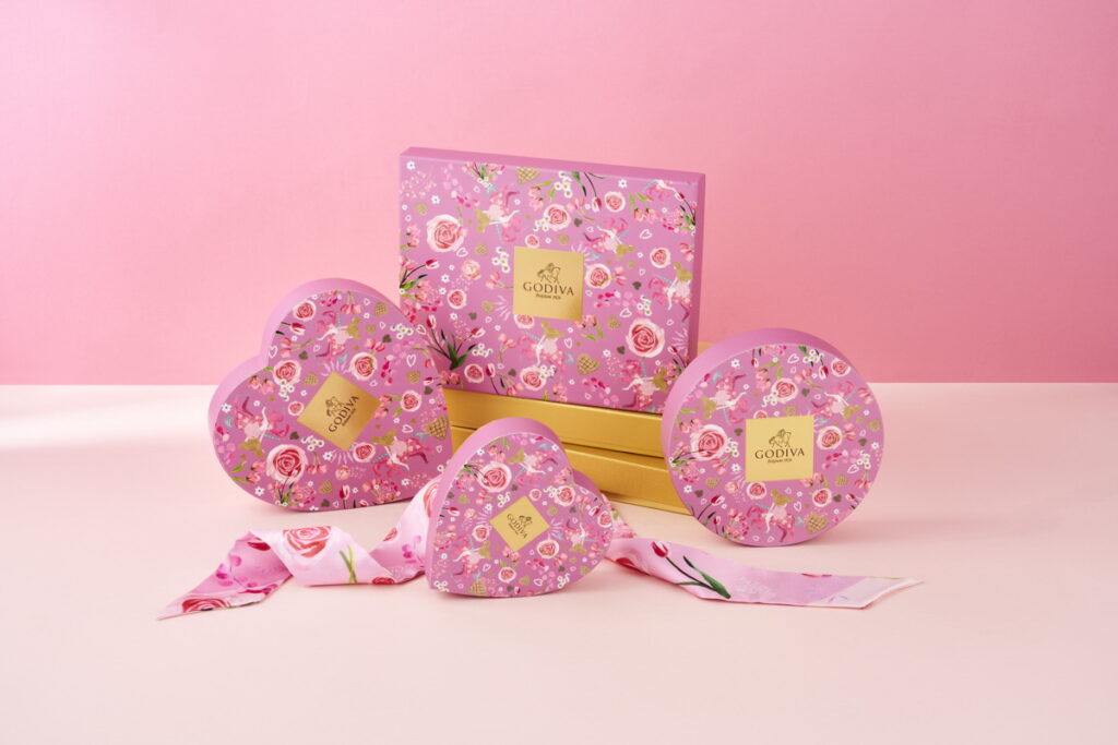 GODIVA情人節禮盒設計極具巧思：少女身騎粉色木馬幸福遨遊，在鮮花與愛心華夫餅等小巧元素的簇擁下，細膩描繪出愛的本真與滿溢的怦然情愫。全系列共有六款別緻巧克力禮盒，以豐富多樣的口味與大小設計滿足各種甜蜜餽贈場合！