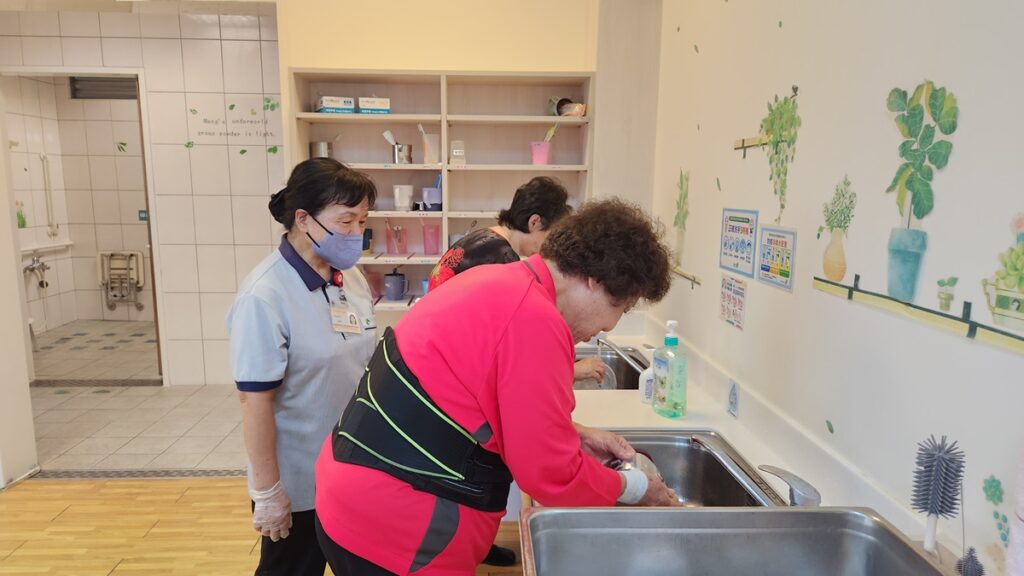 午餐後在日照員陪同下長者們自己動手洗碗，長者們會互相幫助有人洗碗有人收拾餐具。（圖/慈濟清水日照中心提供）