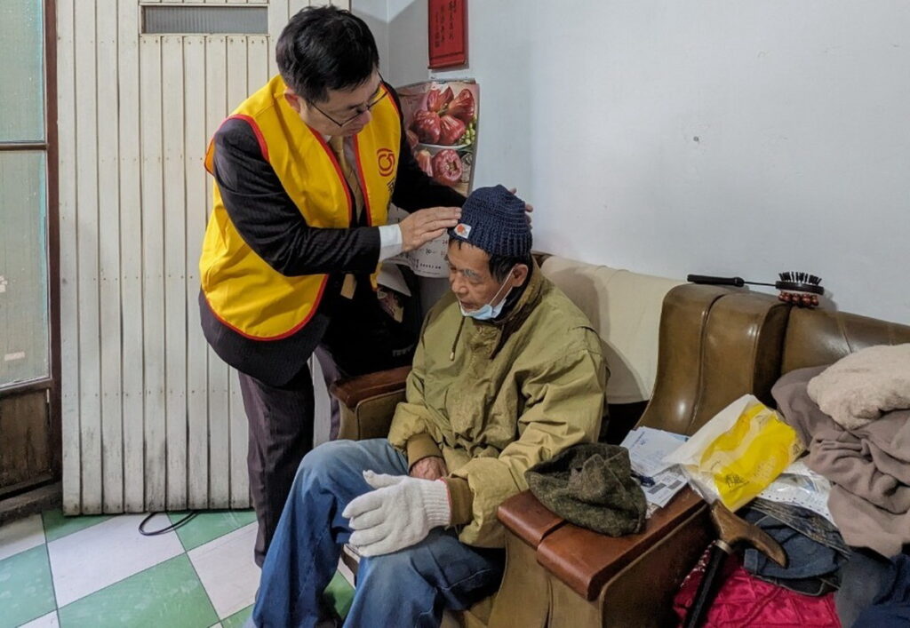 永慶加盟四品牌北區經管會夥伴貼心為爺爺帶上義工手作毛帽。