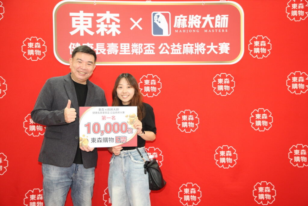 第7屆「健康長壽里鄰盃」公益麻將大賽，最後由27歲的陳小姐(右)技高一籌，奪得冠軍，獲得1萬枚東森Ｅ幣，由東森購物總經理彭鴻珷(左)頒發獎勵。
