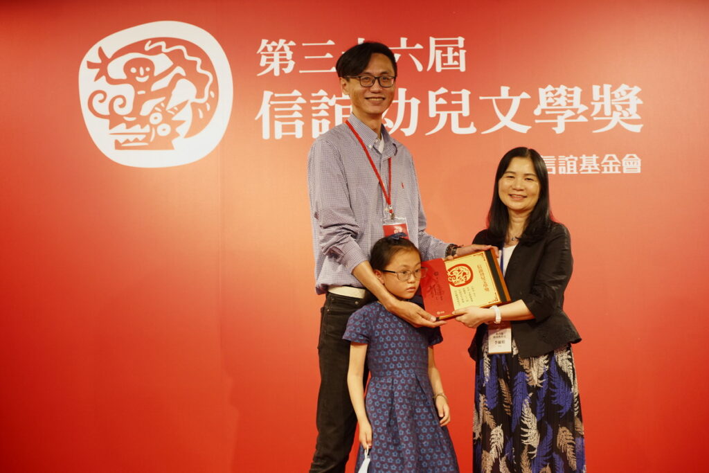 教育部終身教育司李毓娟(右)司長頒發圖畫書佳作獎，《米糕甜蜜蜜》作者(左)攜女兒領獎