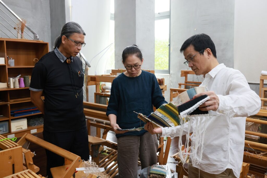 國立臺南藝術大學材質創作與設計系教授陸佳暉(中),說明該系纖維工作室教學場域及學生作品。右為該系鄭正雄主任,左為工藝中心主任陳殿禮(圖/工藝中心提供)