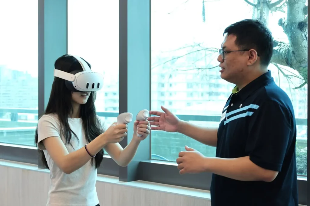 職安系鄭喻齊助理教授(右)引導學生體驗VR防墜設備。(圖/中山醫大提供)