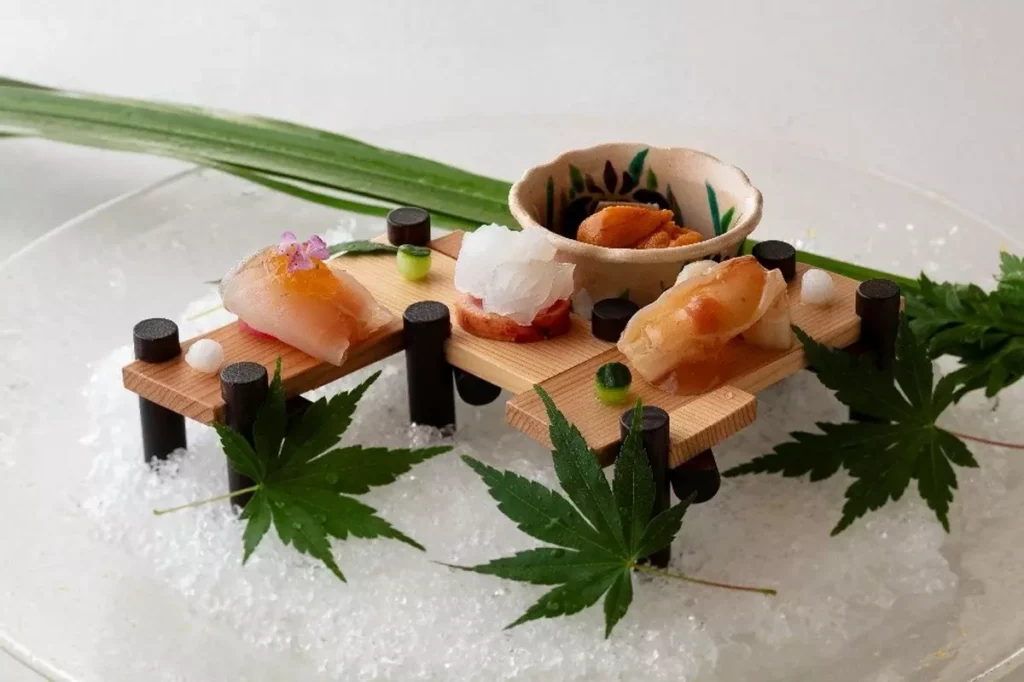 透明冰皿、襯托季節感的青葉，整齊細緻切片的魚料，散發清涼雅致的氛圍。©銀座 小十