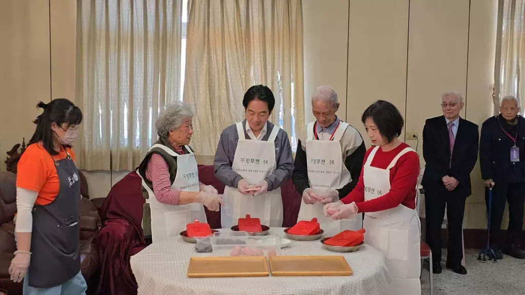 賴總統下廚!祖蔭阿嬤(左二)教大家製作紅龜粿。(圖/陳惠玲攝影)
