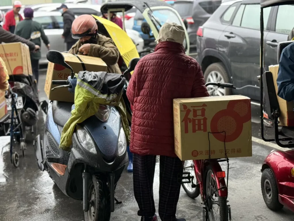 光復鄉居民開心的把年菜食物箱帶回家，與家人過好年