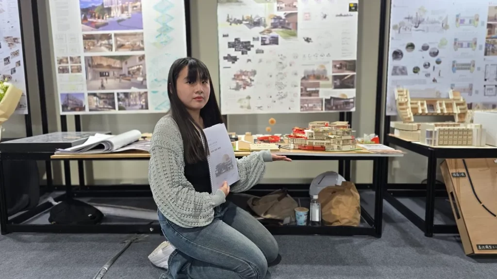 學生林子涵說明作品「垂直動線的穿透性」,保留既有通學動線,並將其轉化為貫穿基地的公共通道;室內則以坡道串聯空間,並圍繞一棵「生長之樹」構築垂直軸線,形塑如劇場般開放且具自然意象的空間體驗。(圖/陳惠玲攝影)