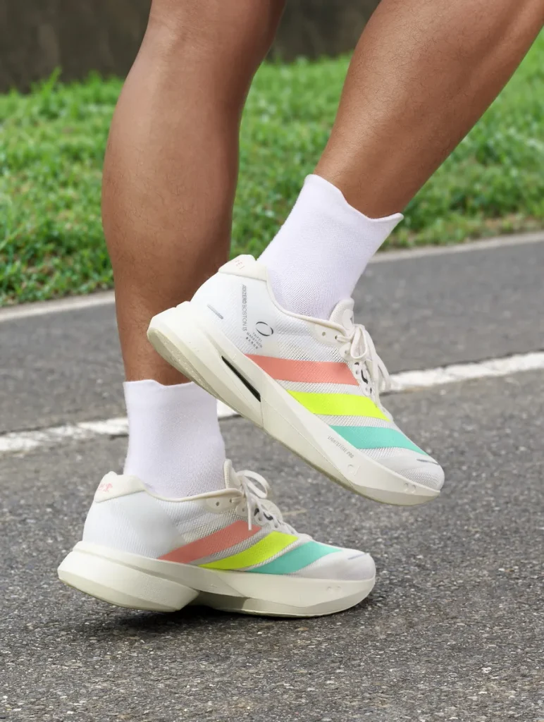 adidas ADIZERO BOSTON 13換上專屬臺北馬拉松的限定設計，鞋側經典三條紋加入夜光效果，呼應夜市霓虹元素。